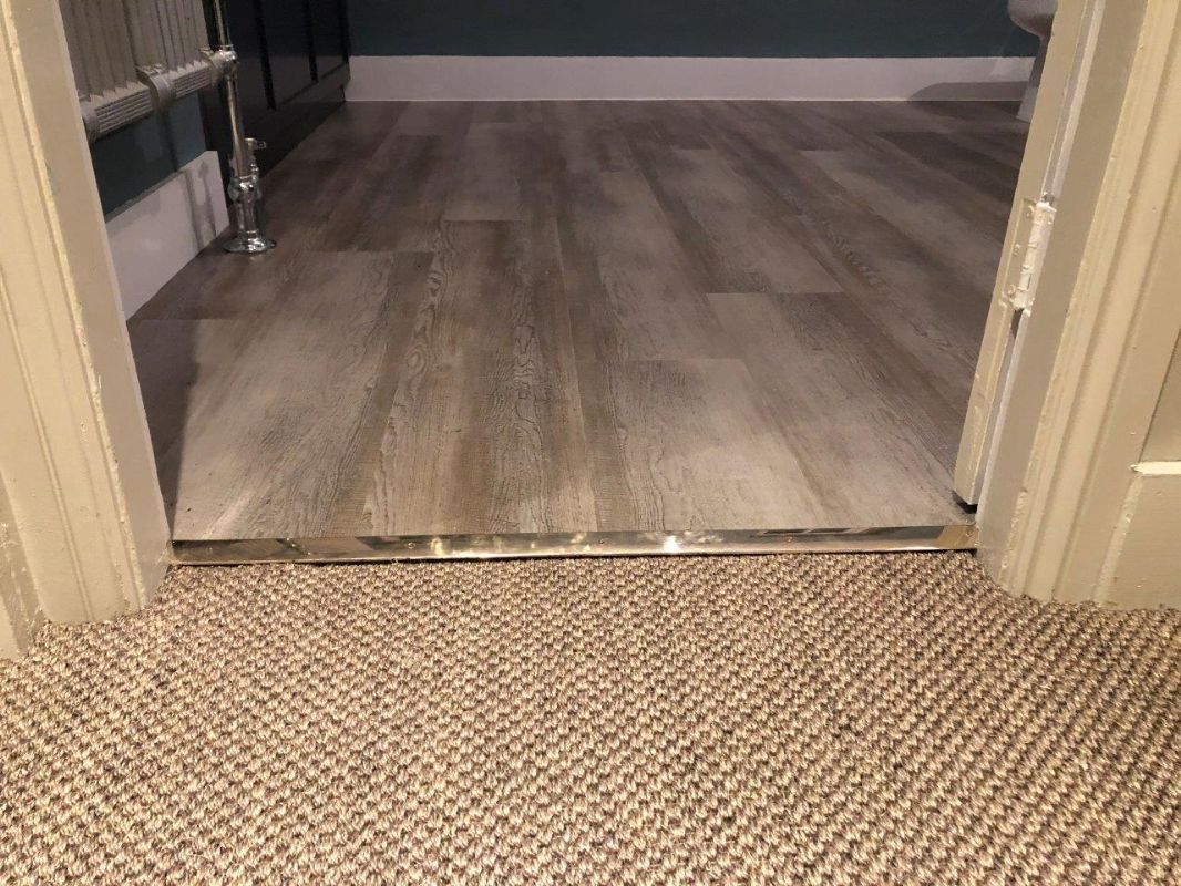 Sisal flooring meeting oak-effect plank at a doorway in a Stroud home